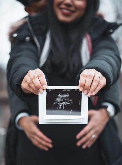 Couple showing their baby's ultrasound photo.