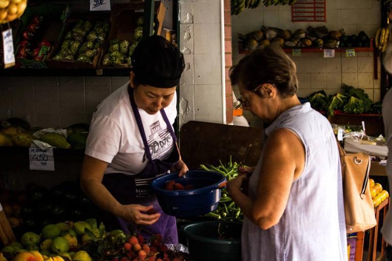 Woman buying fruit from a merchant.