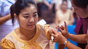 Woman getting a shot in the shoulder.