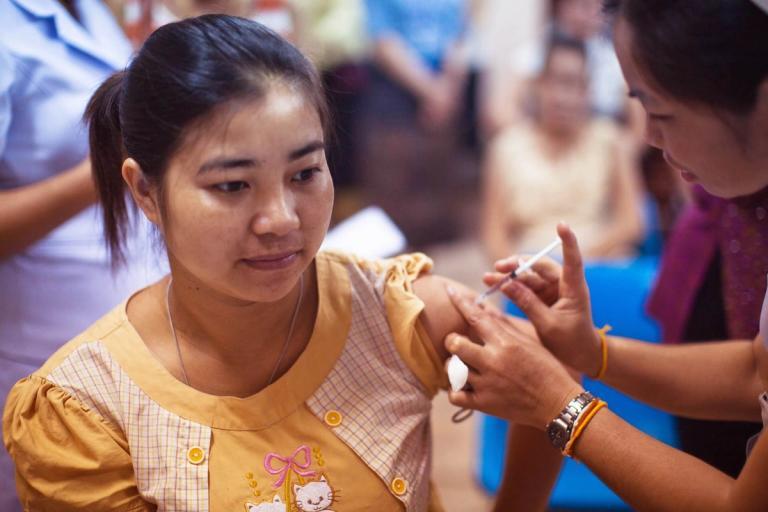 Woman getting a shot in the shoulder.