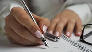 Woman writing plans in a notebook.