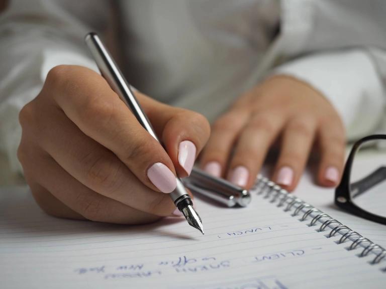 Woman writing plans in a notebook.