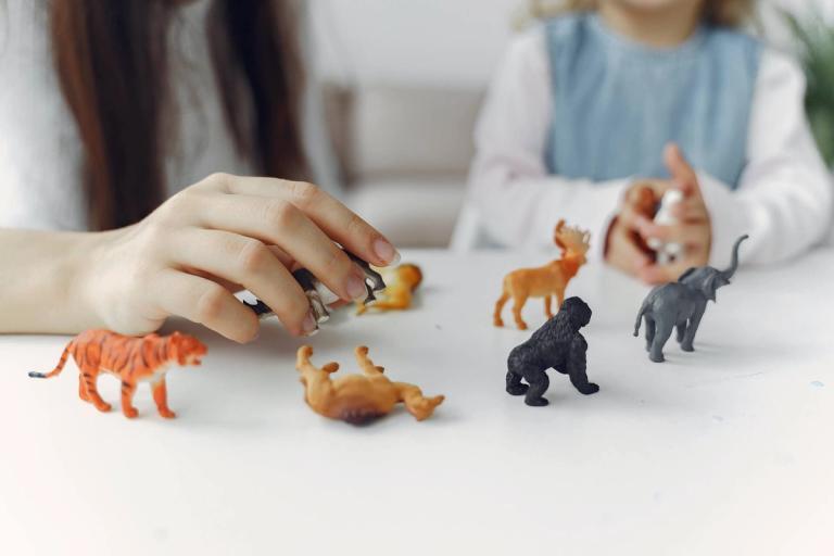 A mother and daughter playing with toy animals.