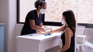 A nurse performing a test on a patient's arm.