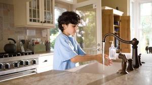 Young kid washing hands with soap.