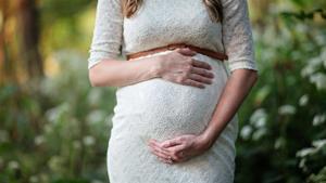 Pregnant woman caressing her stomach.