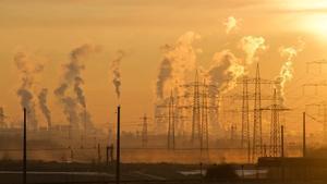 Factory smokestacks spewing smoke.