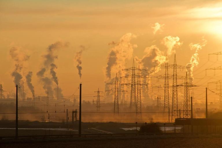 Factory smokestacks spewing smoke.