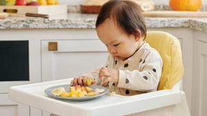 Baby eating finger foods.