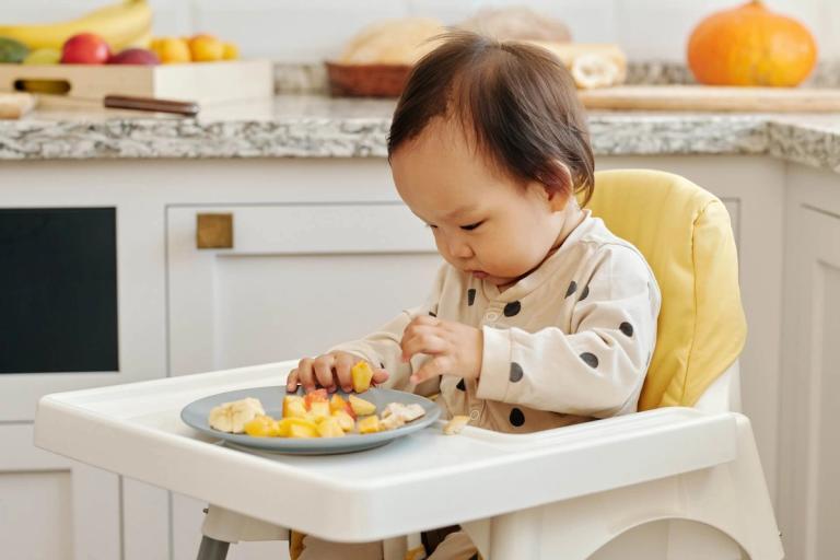 Baby eating finger foods.