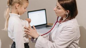 Doctor using a stethoscope on a young girl.